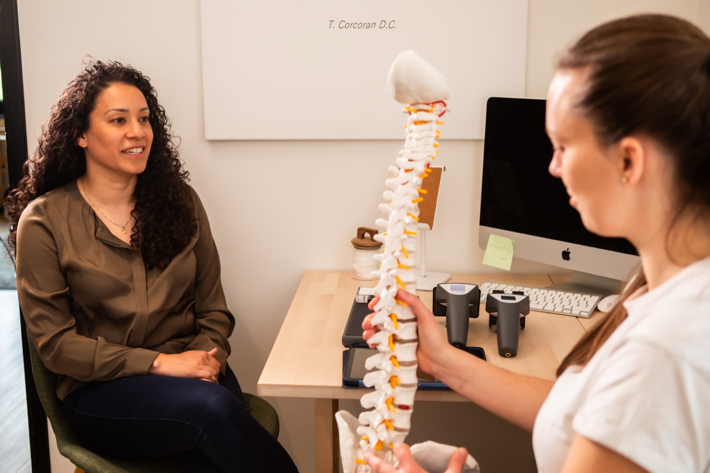 Chiropractor legt met een wervelkolommodel uit wat de scan laat zien bij TOPCHIRO Breda